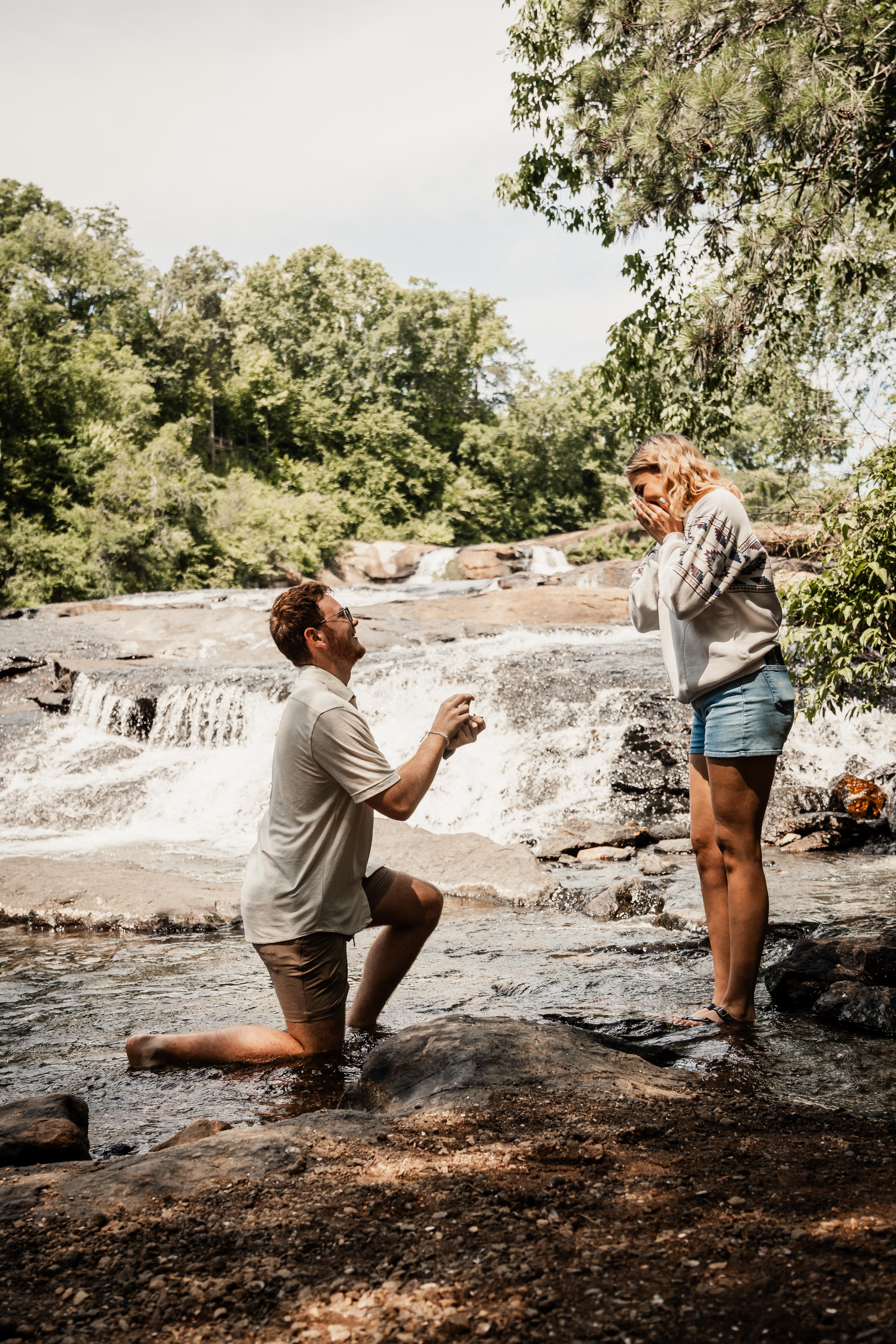 Man proposing to girlfriend at waterfall