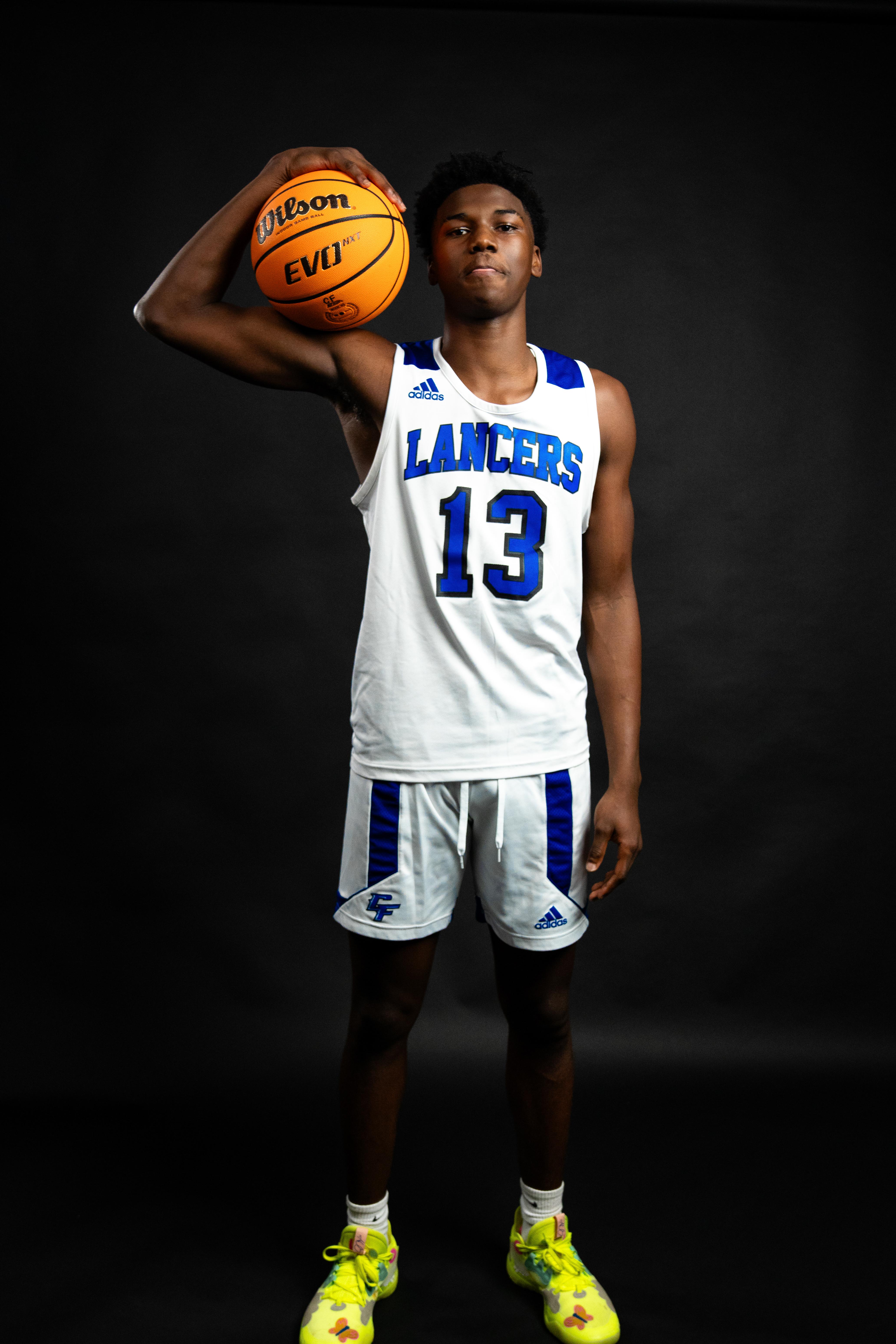 Basketball player posing in front of black cyclorama